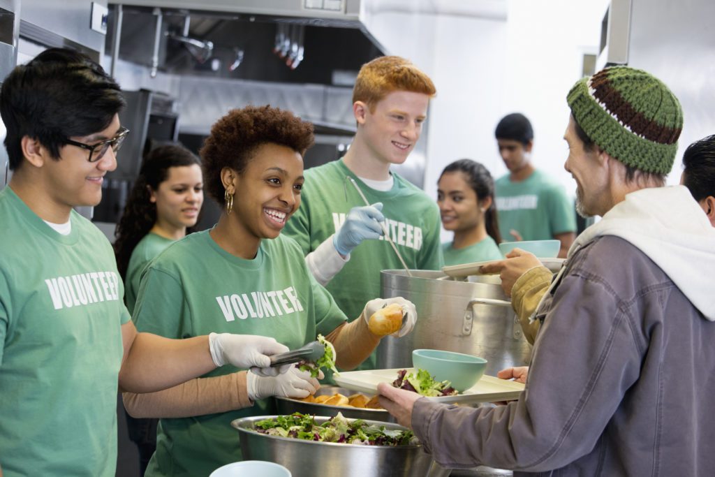 Photo of volunteers having a feeding program to the homeless